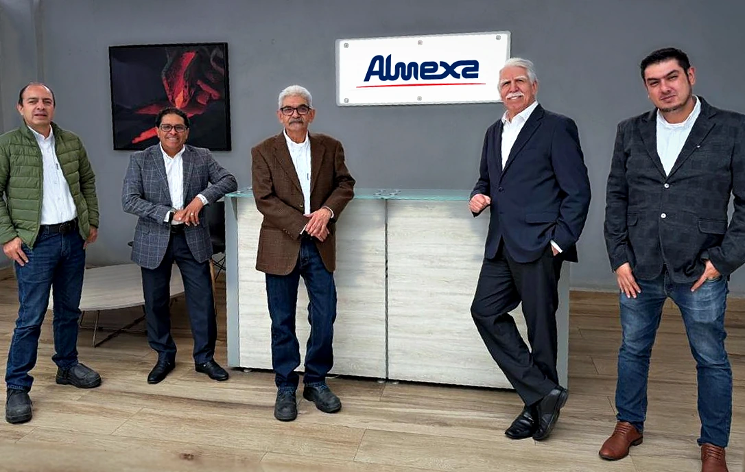 The Almexa team at the reception of its offices, in front of the Almexa sign